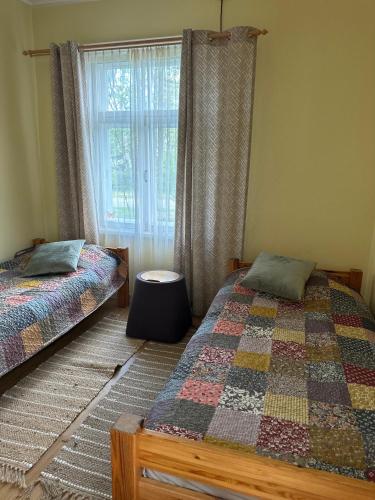 a bedroom with two twin beds and a window at Bruno māja in Strenči