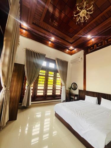 a bedroom with a bed and a chandelier at An Haven Villa in Phú Xá