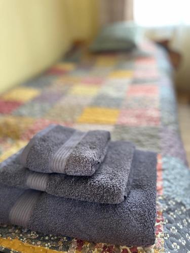 a pile of towels sitting on top of a bed at Bruno māja in Strenči