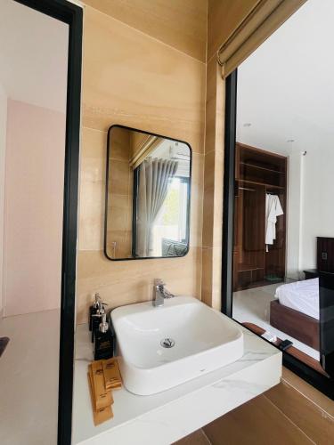 a bathroom with a sink and a mirror at An Haven Villa in Phú Xá
