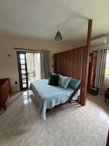 a bedroom with a bed with a wooden headboard at A casa do vale in Bananeiras
