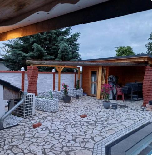 eine Terrasse mit Steinboden und ein Backsteinhaus in der Unterkunft Pooloase in Colbitz