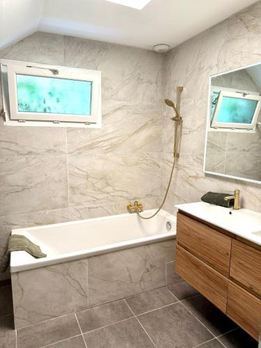 a bathroom with a tub and a sink and a window at Villa Muvra in Ajaccio