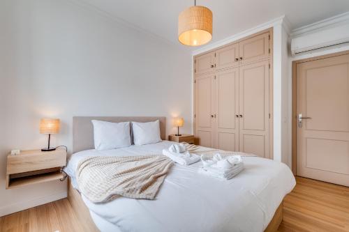 a bedroom with a white bed with two towels on it at Albufeira prime stay in Albufeira