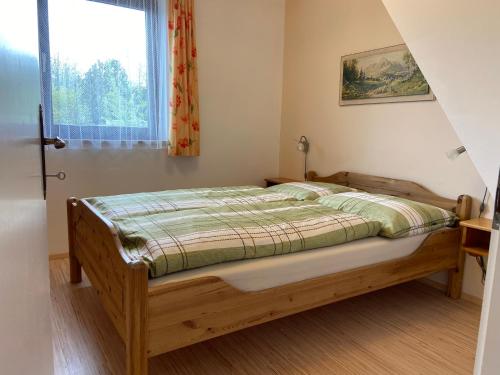 a bedroom with a bed in a room with a window at Das Sunnhäusl in Mariapfarr