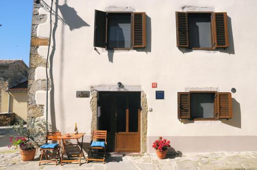 a building with a table and chairs and windows at Casa Stella in Draguć