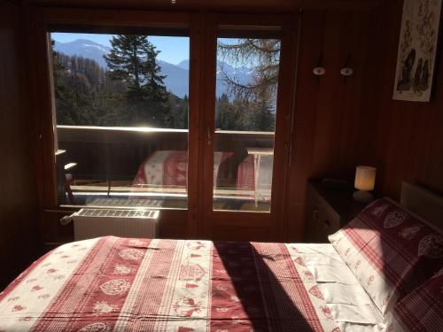 1 dormitorio con cama y ventana con vistas en Renovated Mountain View Apartment - Les Eperviers, en Crans-Montana
