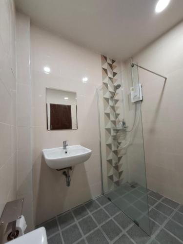 a bathroom with a sink and a shower at สายป่าน เฮ้าส์ แพร่ in Ban San Pa Yae