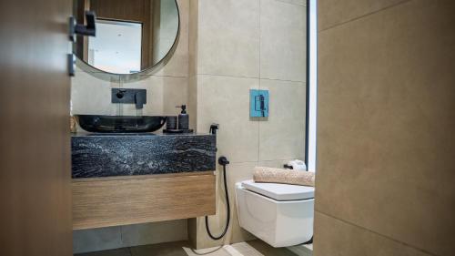 a bathroom with a sink and a toilet and a mirror at Bustan Alsafia بستان الصافية in Nizwa