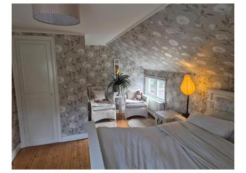a bedroom with a bed and a couch and chairs at Kulla Gard in Ingarö