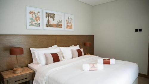 two beds in a hotel room with white sheets at Bustan Alsafia بستان الصافية in Nizwa