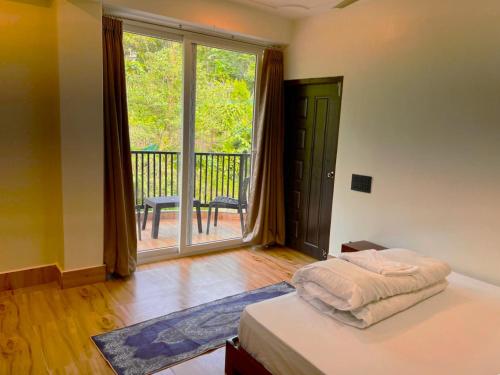 a bedroom with a bed and a large window with a balcony at Happy Homestay Sittong in Mangpu