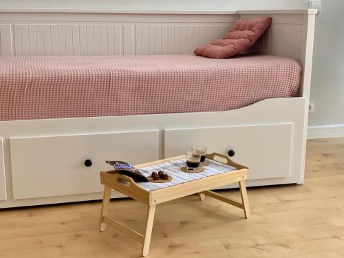 a small table in front of a bed at Nida in Nida