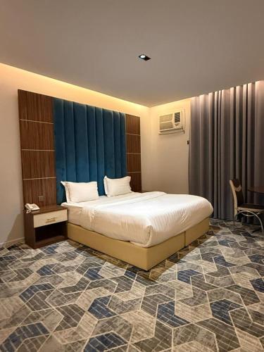a bedroom with a bed in a room with blue curtains at كيان الين الشبلان - KAYAN ALYN AlMansak Suites in Abha