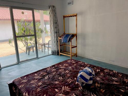 a bedroom with a bed and a large window at Summer wave kudawa and Kite surfing school in Kalpitiya