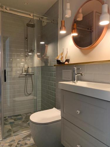 a bathroom with a shower and a toilet and a sink at Nida in Nida