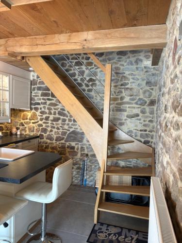 a staircase in a kitchen with a stone wall at Le Menes in Andenne
