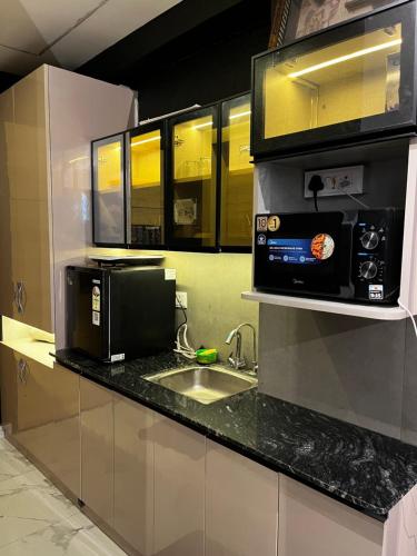 a kitchen with a sink and a microwave at Moon Escape Studio in Ghaziabad