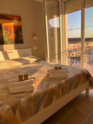 a bedroom with a bed with two towels on it at Casa Ezio beach&relax in Chioggia