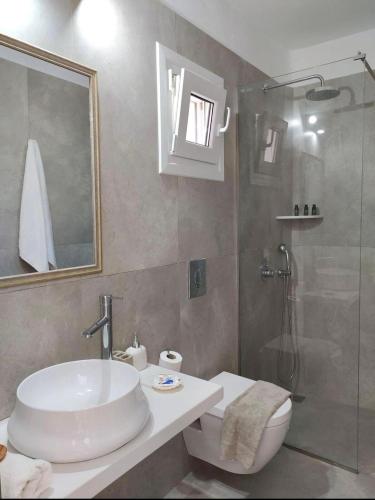 a bathroom with a toilet and a sink and a shower at NIKOLAS HOUSE CLOSE To TOWN in Mikonos