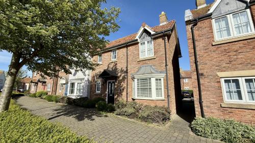 a brick house with white windows on a street at Baileys Beach House - Part of the The Bay Filey Holiday Village with pool, gym and direct beach access, pub, restaurant, tennis and meadows walks in Filey