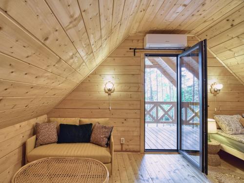 an attic room with a couch and a window at Na Las Czas in Sompolno