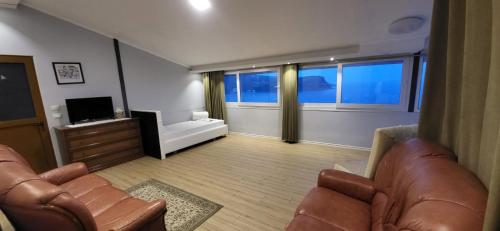a living room with two chairs and a flat screen tv at Jon rooms in Himare