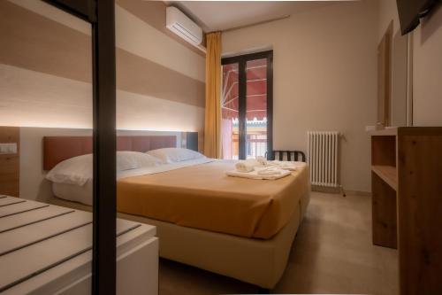 a bedroom with a large bed and a window at Hotel Primavera in Peschiera del Garda