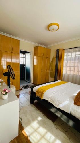a bedroom with a bed and a room with a table at Godly Homes in Ruiru