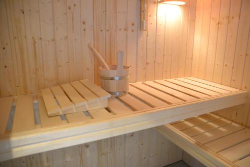 a sauna with wooden shelves and a bucket of utensils at Pension Adlerhorst in Ramsau am Dachstein