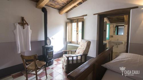 a bedroom with a fireplace and a bed and a chair at CASA CAULI agriturismo in Arenabianca