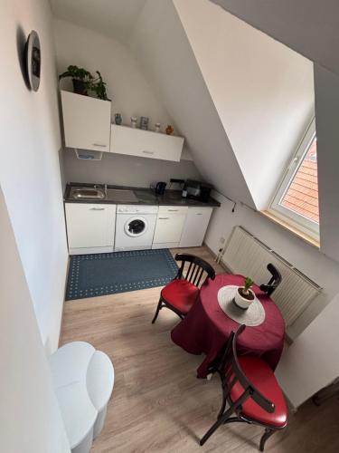 a small kitchen with a table and chairs in a room at Bright studio-flat near station - Bayreuth in Bayreuth