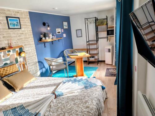 a bedroom with blue walls and a bed and a table at Le Clos des Passiflores in Pons