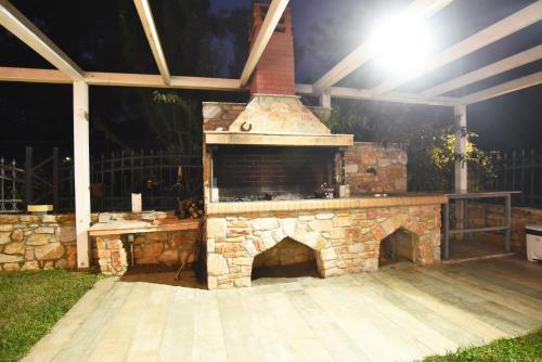 a stone fireplace in a backyard at night at Laida studios in Prinos
