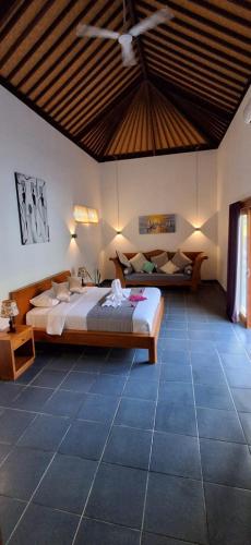 a bedroom with a bed and a couch in a room at Villa Rosa East Bali in Karangasem