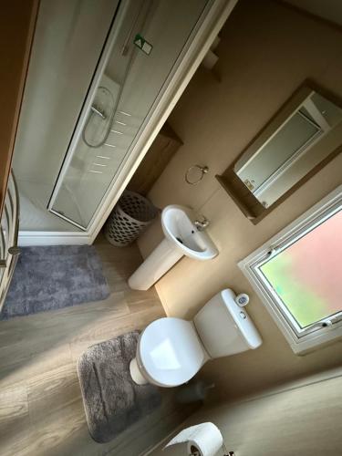 a bathroom with a toilet and a sink and a mirror at Elite Retreat Caravan in Blackpool