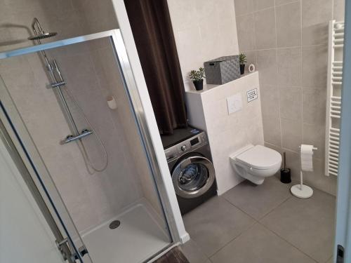 a bathroom with a shower and a washing machine at T2 cozy vue mer in Pietrosella