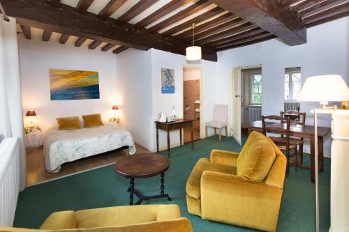 a bedroom with a bed and a table and chairs at Auberge du Manoir d'Archelles in Arques-la-Bataille