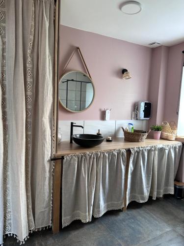 a dressing table in a room with a mirror at Le Pressoir des Maisons de Blanche in Lengronne