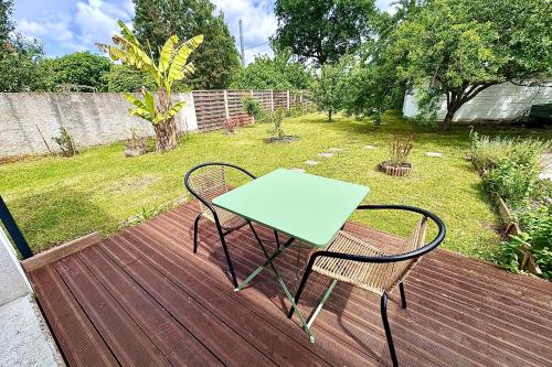 a wooden deck with a table and chairs on it at Bright house with garden in Saint-Sébastien-sur-Loire