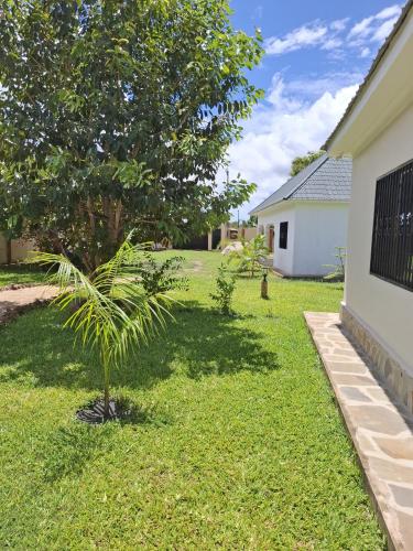 a palm tree in the yard of a house at Ferienhaus Vacation Villa Diani Beach in Kinondo