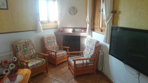 sala de estar con sillas y chimenea en Casa Rural Pastora Marcela, en Saceruela