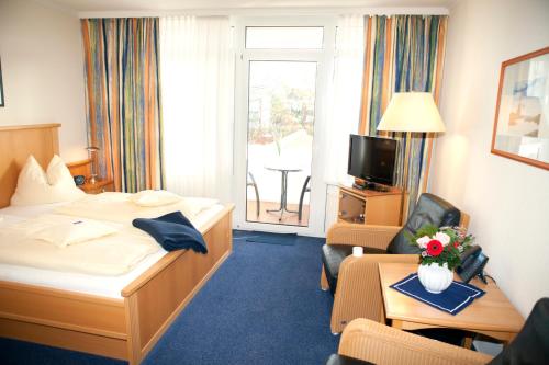 a hotel room with a bed and a living room at Hotel Mellum in Wangerland