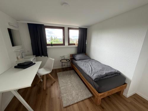 a small bedroom with a bed and a desk at Landhaus zur Sonne in Bad Camberg