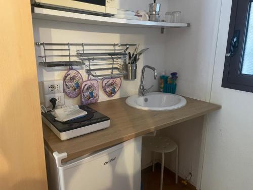 a kitchen counter with a sink and plates on a shelf at Nonna Antonietta in San Teodoro