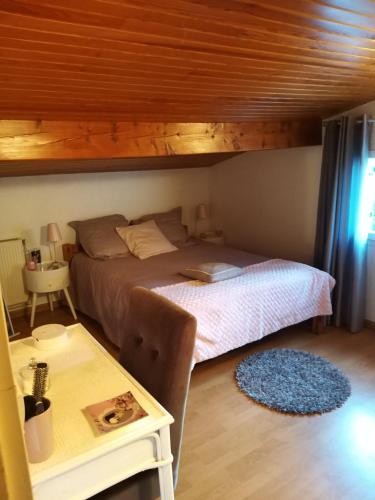 a bedroom with a bed and a table at Maison prés d'Agen in Bon-Encontre