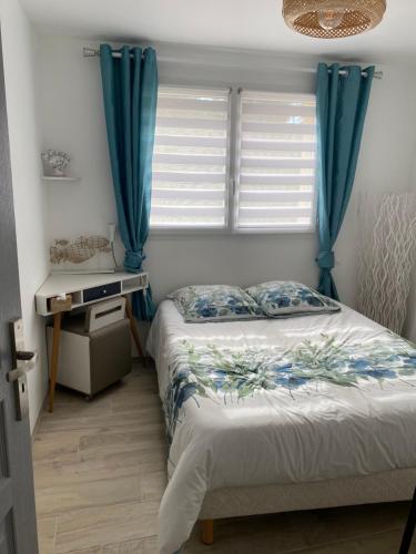 a bedroom with a bed and a window with blue curtains at Les clés du temps in Essarts