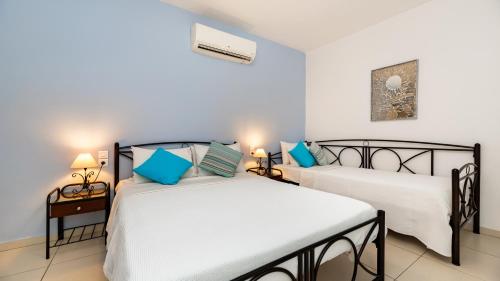 two beds in a room with blue and white at Stelios Place in Perissa