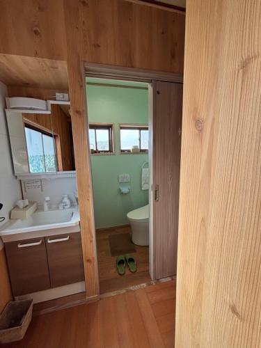 a bathroom with a toilet and a sink and a mirror at 魚沼ヒミツ基地 in Uonuma