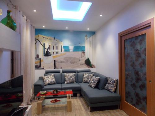 a living room with a blue couch and a painting at Vico 59 in Ortona